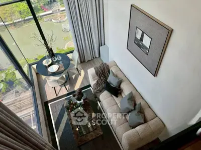 Stunning modern living room with floor-to-ceiling windows and scenic river view.
