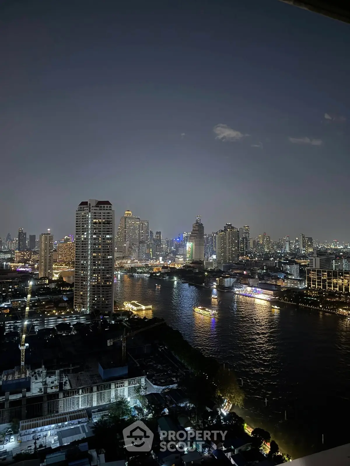 Stunning cityscape view of a vibrant skyline and river at night, perfect for urban living enthusiasts.