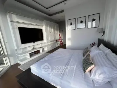 Luxurious bedroom with modern decor and large TV, perfect for relaxation and entertainment.