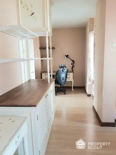 Charming study room with vintage white wooden desk, ample shelving, and a cozy workspace nook with natural light filtering through the curtains.