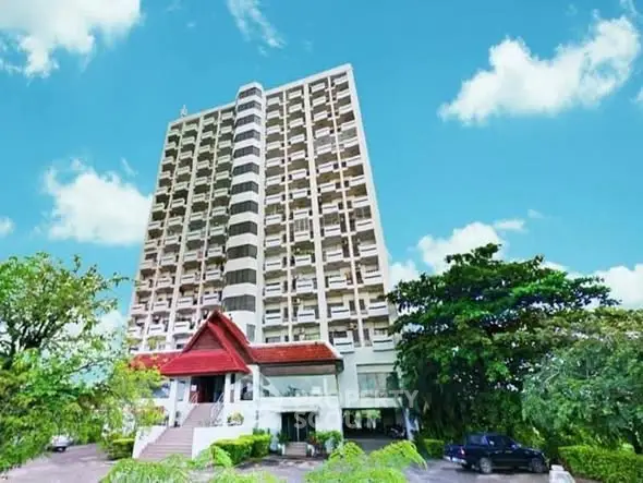 Stunning high-rise building with lush greenery and clear blue sky, perfect for urban living.