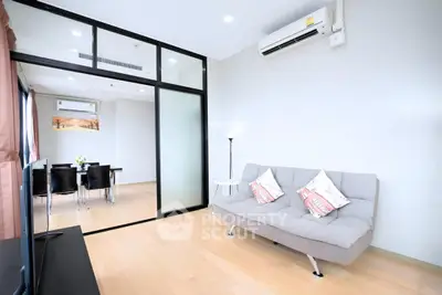 Modern living room with sleek glass partition and cozy seating area