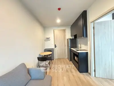 Modern compact living room with kitchenette and dining area in sleek apartment