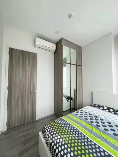 Modern bedroom with stylish decor and mirrored wardrobe in a bright apartment.