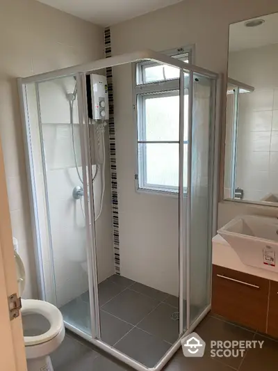 Modern bathroom with glass shower enclosure and sleek vanity unit