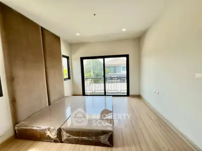Spacious bedroom with large windows and balcony access in modern home