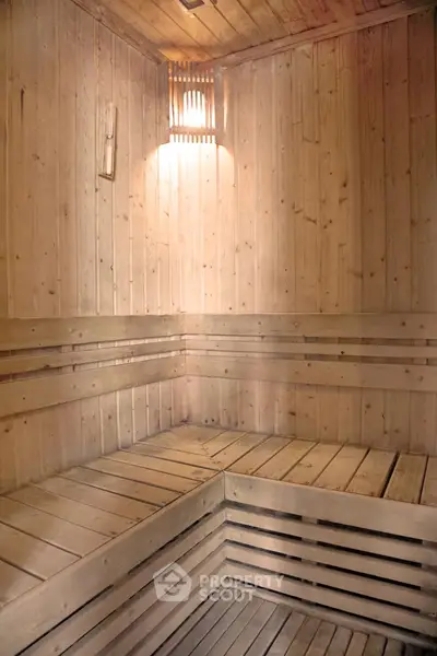 Luxurious wooden sauna room with warm lighting and spacious seating, perfect for relaxation and wellness.
