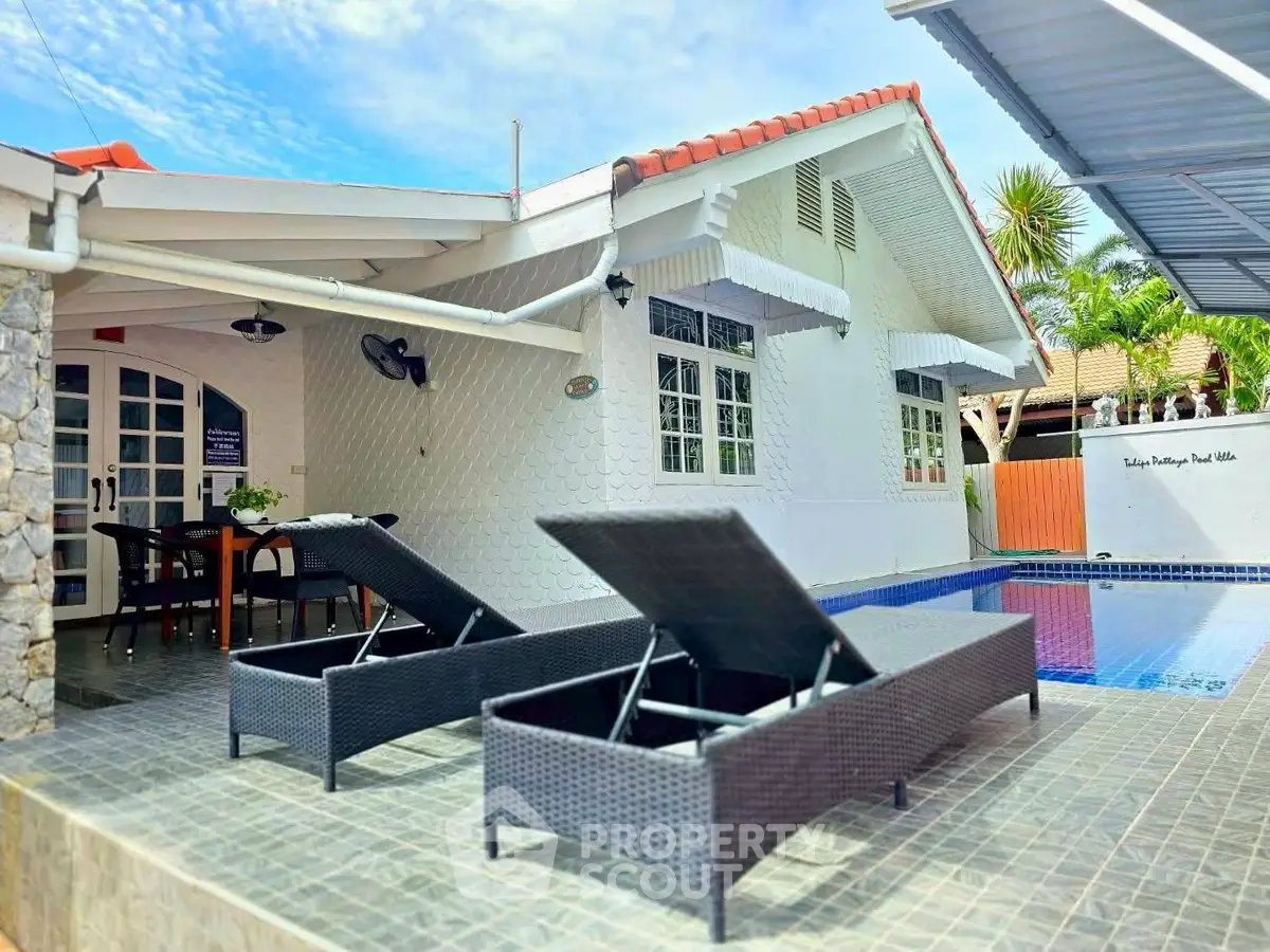 Charming poolside villa with sun loungers and modern architecture, perfect for relaxation and entertaining.