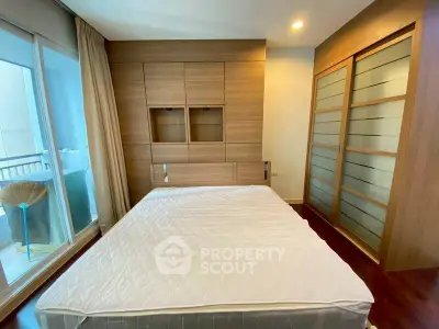 Modern bedroom with wooden accents and balcony access in a stylish apartment.