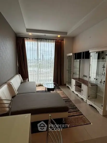 Modern living room with large windows and stylish furniture in a high-rise apartment.