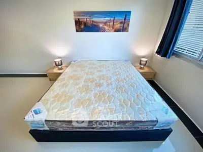 Modern bedroom with a new mattress, stylish lamps, and serene wall art.