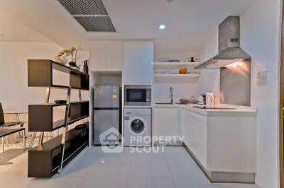 Modern kitchen with sleek white cabinets, built-in appliances, and stylish shelving in a contemporary apartment.