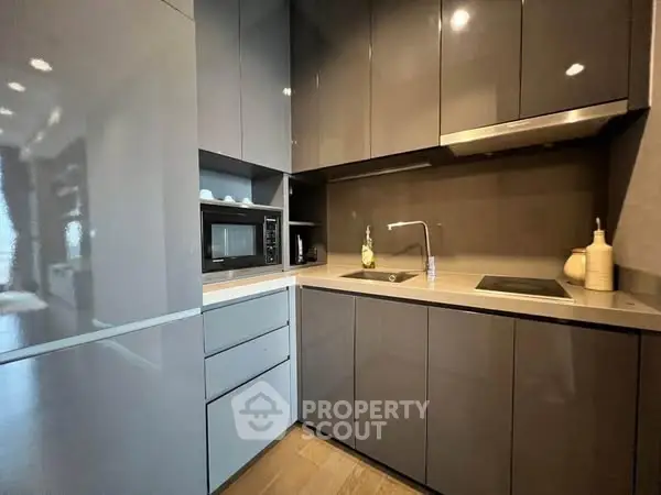 Modern kitchen with sleek cabinetry and built-in appliances in a compact layout.