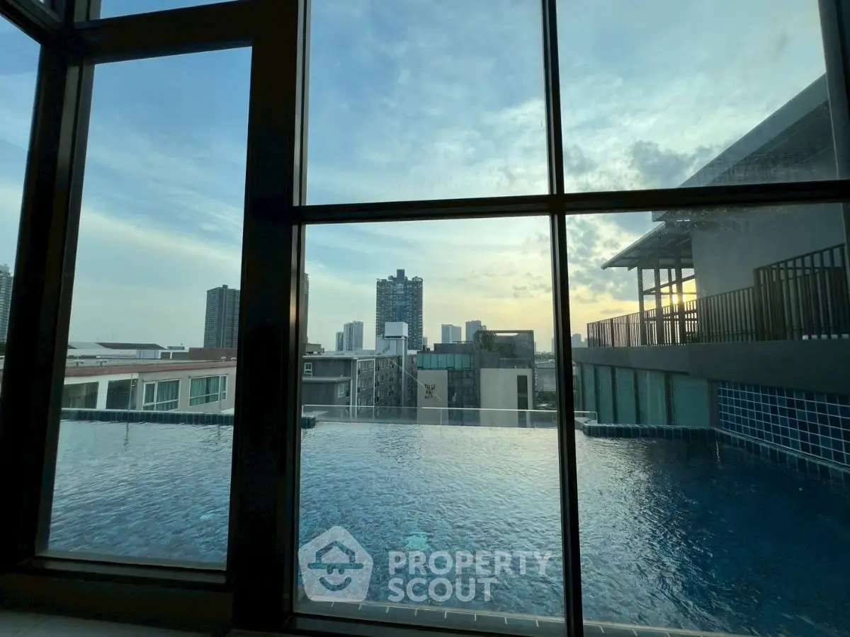 Stunning rooftop pool with city skyline view at sunset, perfect for relaxation.