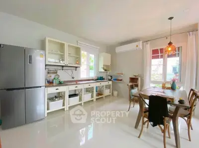 Spacious kitchen with modern appliances and dining area, featuring open layout and natural light.