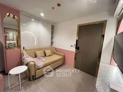 Modern living room with stylish decor, featuring a beige sofa, sleek white cabinets, and a terrazzo countertop.