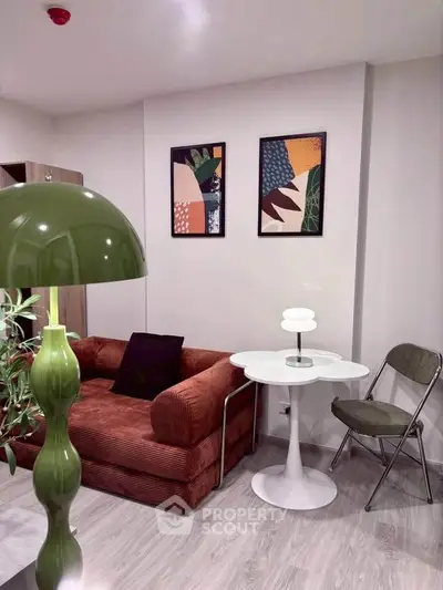 Stylish living room with modern decor, featuring a cozy sofa, chic lamp, and contemporary artwork.