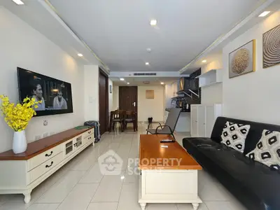 Modern living room with open kitchen, stylish decor, and cozy seating area.