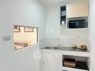 Modern compact kitchen with sleek design and built-in microwave