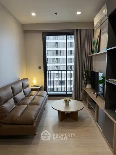 Modern living room with sleek furniture and large window in urban apartment