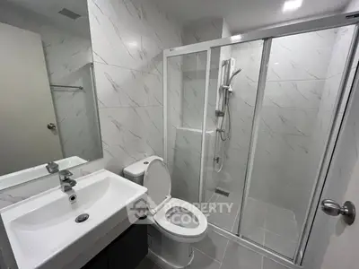 Modern bathroom with sleek shower enclosure and contemporary fixtures.