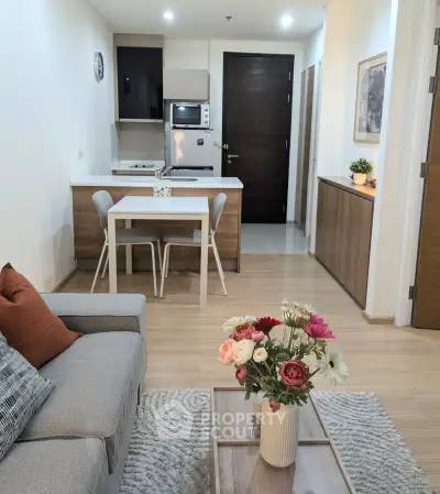 Modern open-layout living room with cozy seating and stylish kitchen area.