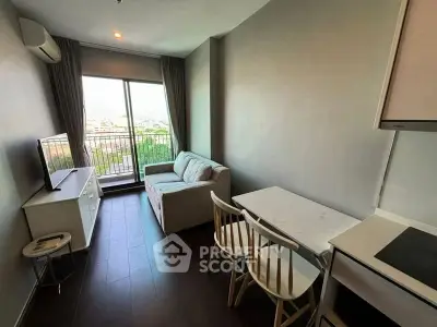 Modern living room with balcony view, featuring cozy sofa and dining area in a compact apartment.