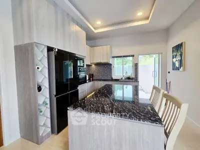 Modern kitchen with sleek black granite countertops and open layout design.