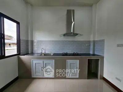 Modern kitchen with sleek cabinetry and gas stove, featuring a minimalist design and ample natural light.