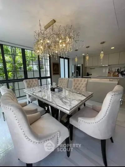 Luxurious dining area with elegant chandelier and marble table in modern home.