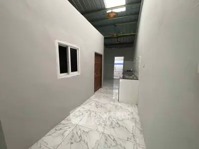 Modern kitchen with sleek marble flooring and minimalist design, featuring a compact layout and contemporary fixtures.