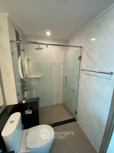Modern bathroom with glass shower enclosure and sleek fixtures