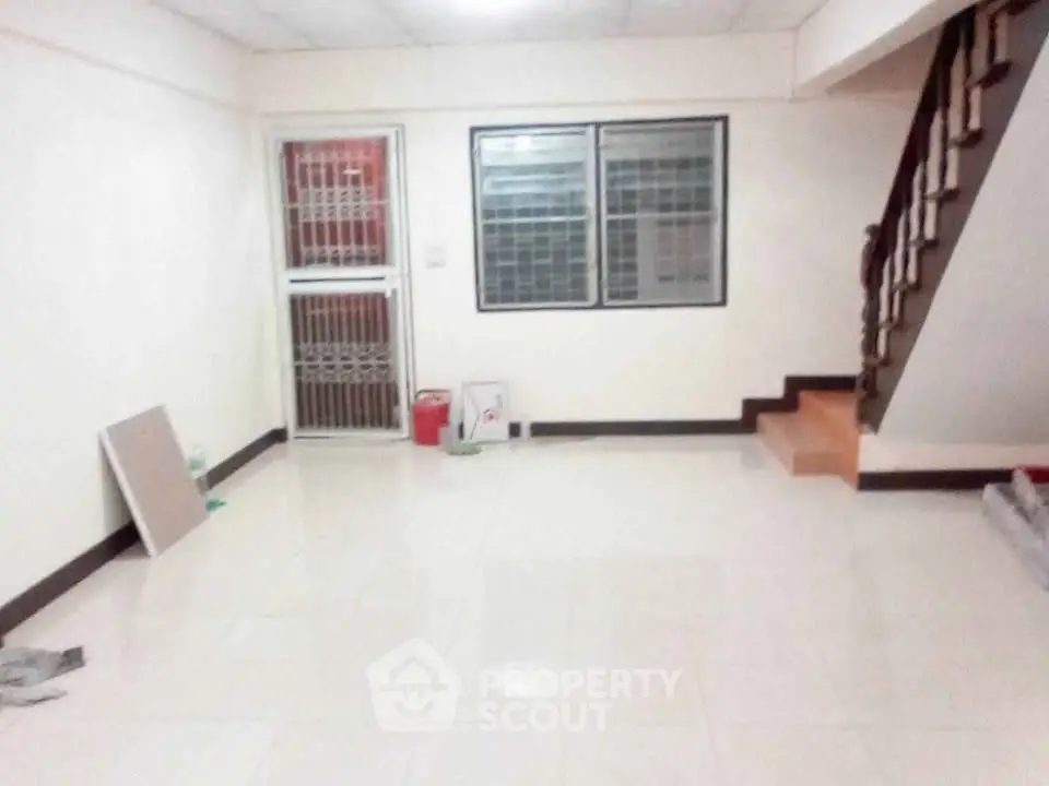 Spacious unfurnished living room with staircase and tiled floor