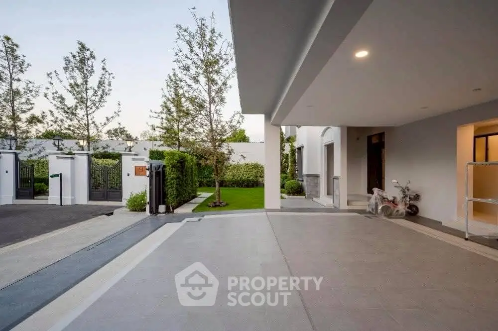 Modern luxury home exterior with spacious driveway and lush garden