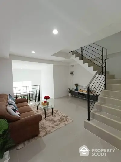 Modern living room with stylish staircase and cozy seating area