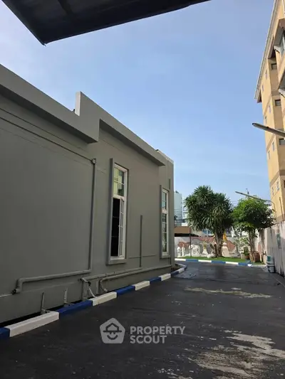 Modern building exterior with clear blue sky and palm trees, ideal for commercial real estate.