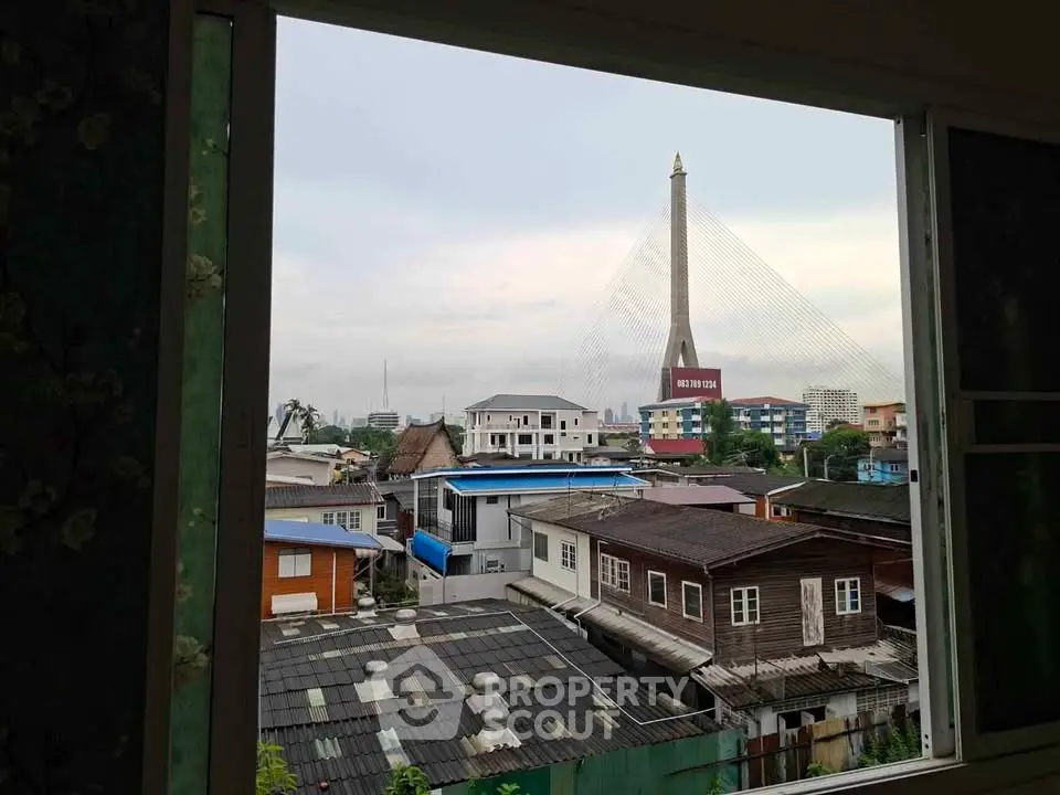 Stunning cityscape view from a window showcasing a modern bridge and urban skyline.