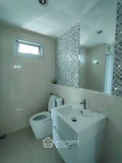 Modern bathroom with stylish mosaic tiles and sleek fixtures.