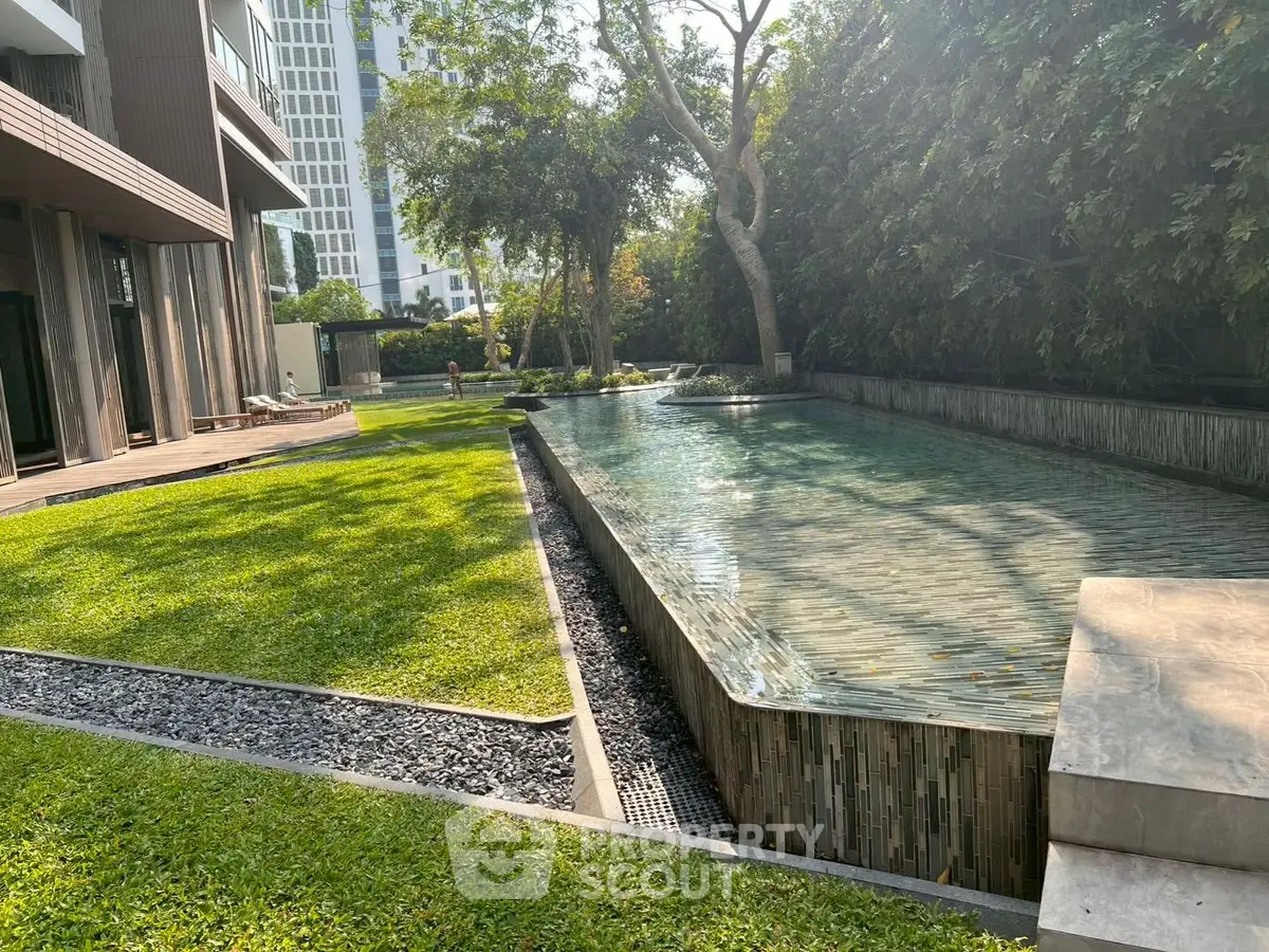 Luxurious modern building with serene pool and lush garden view