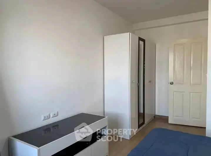 Minimalist bedroom with sleek wardrobe and modern furniture.