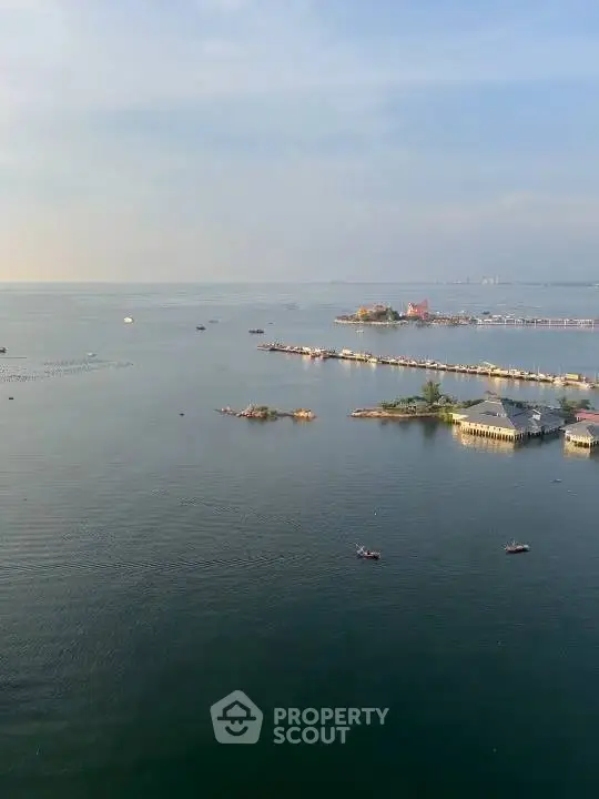 Stunning waterfront view with serene ocean and distant structures, perfect for tranquil living.