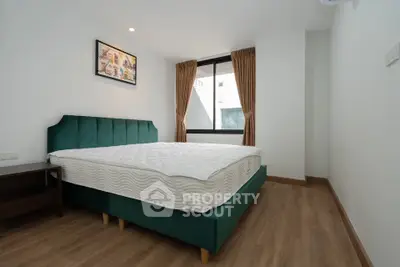 Spacious bedroom with modern decor and large window for natural light