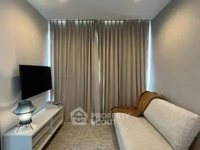 Cozy living room with modern decor and neutral tones, featuring a sleek TV setup and elegant curtains.