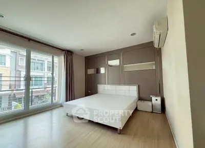 Spacious bedroom with large windows and modern design in a stylish apartment.