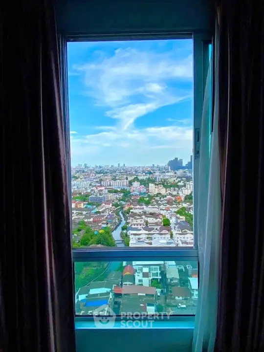 Stunning cityscape view from a high-rise window, showcasing urban skyline and vibrant blue sky.