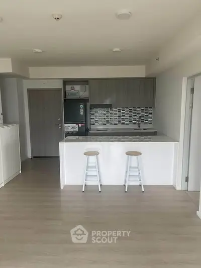 Modern kitchen with sleek cabinetry and breakfast bar in a stylish apartment.