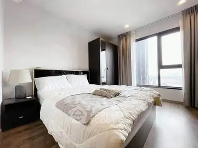 Spacious modern bedroom with large window and stylish furnishings