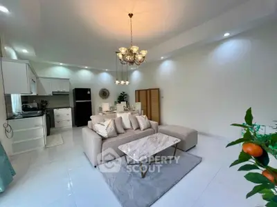 Spacious modern living room with elegant chandelier and open kitchen layout