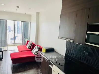 Modern apartment with open layout, featuring sleek kitchen and vibrant red seating area, offering city views.