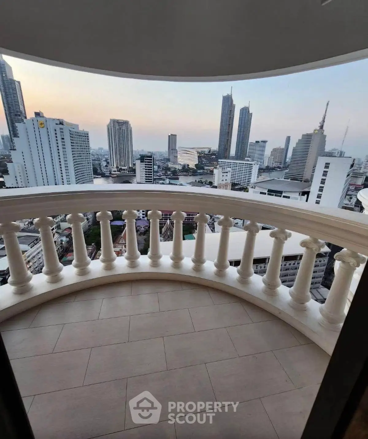 Stunning cityscape view from a luxurious curved balcony in a high-rise building.